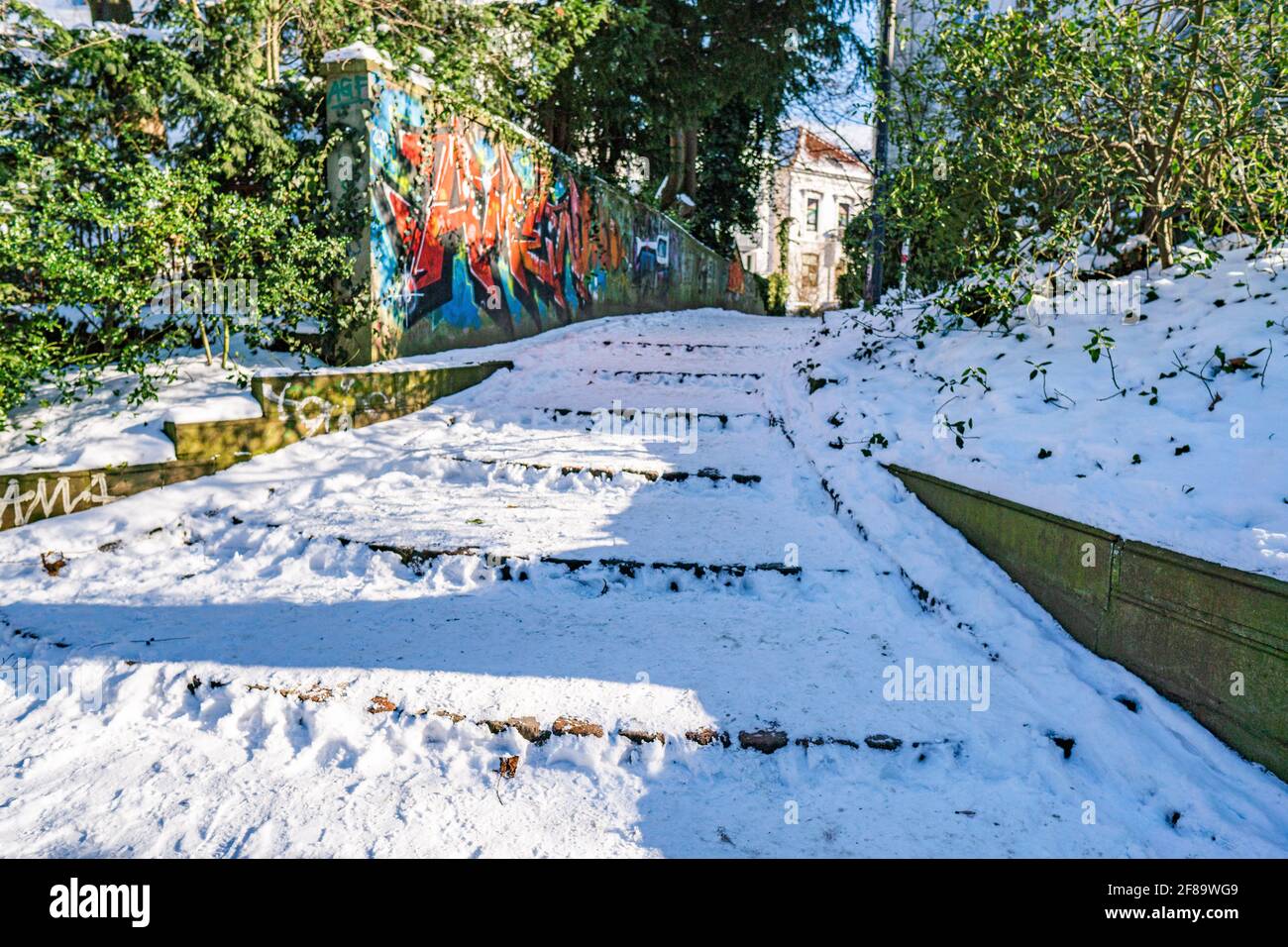 Verschneite Treppe und Wand aus Graffiti am Stadtwall in bremen An sonnigen, warmen Wintertagen Stockfoto