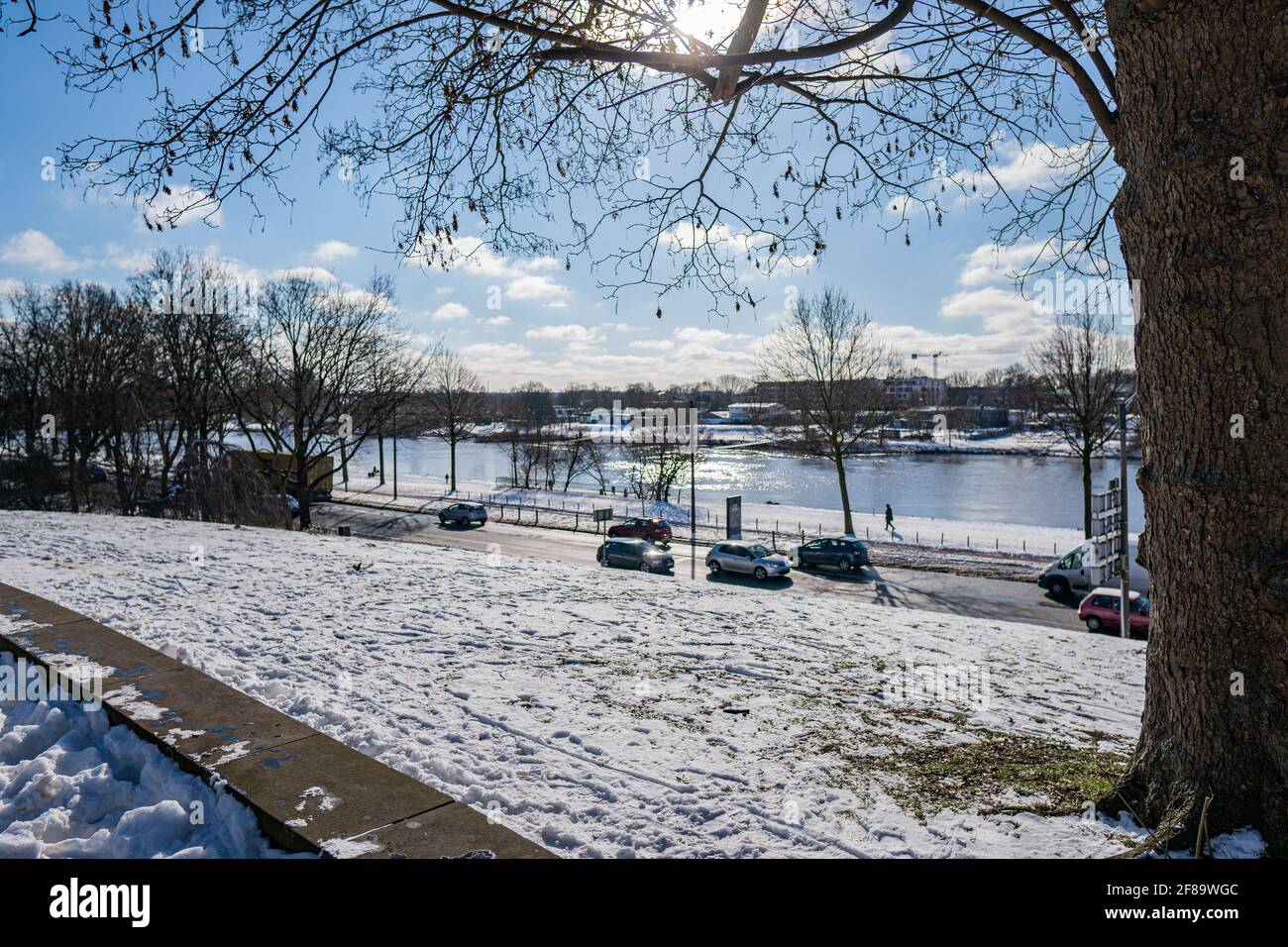 Blick vom verschneiten Wall auf Deich, weser und werdersee bei sonnigem, warmem Wintertag in bremen Stockfoto