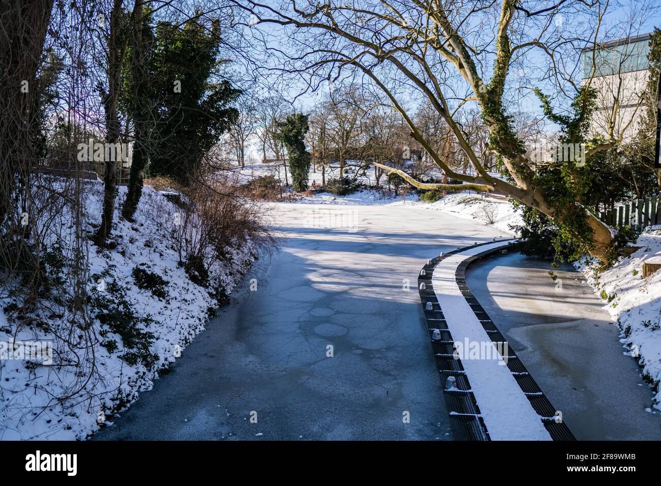 Kleiner verschneite Gehweg über dem Wasser neben dem Theaterplatz und Kunstgalerie in bremen an sonnigen, warmen Wintertagen Stockfoto