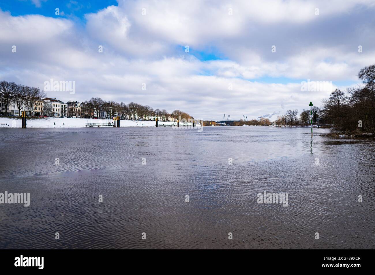 Blick über die weser und den verschneiten osterdeich vom Holzsteg aus Im Winter in bremen mit Stadion im Hintergrund Stockfoto