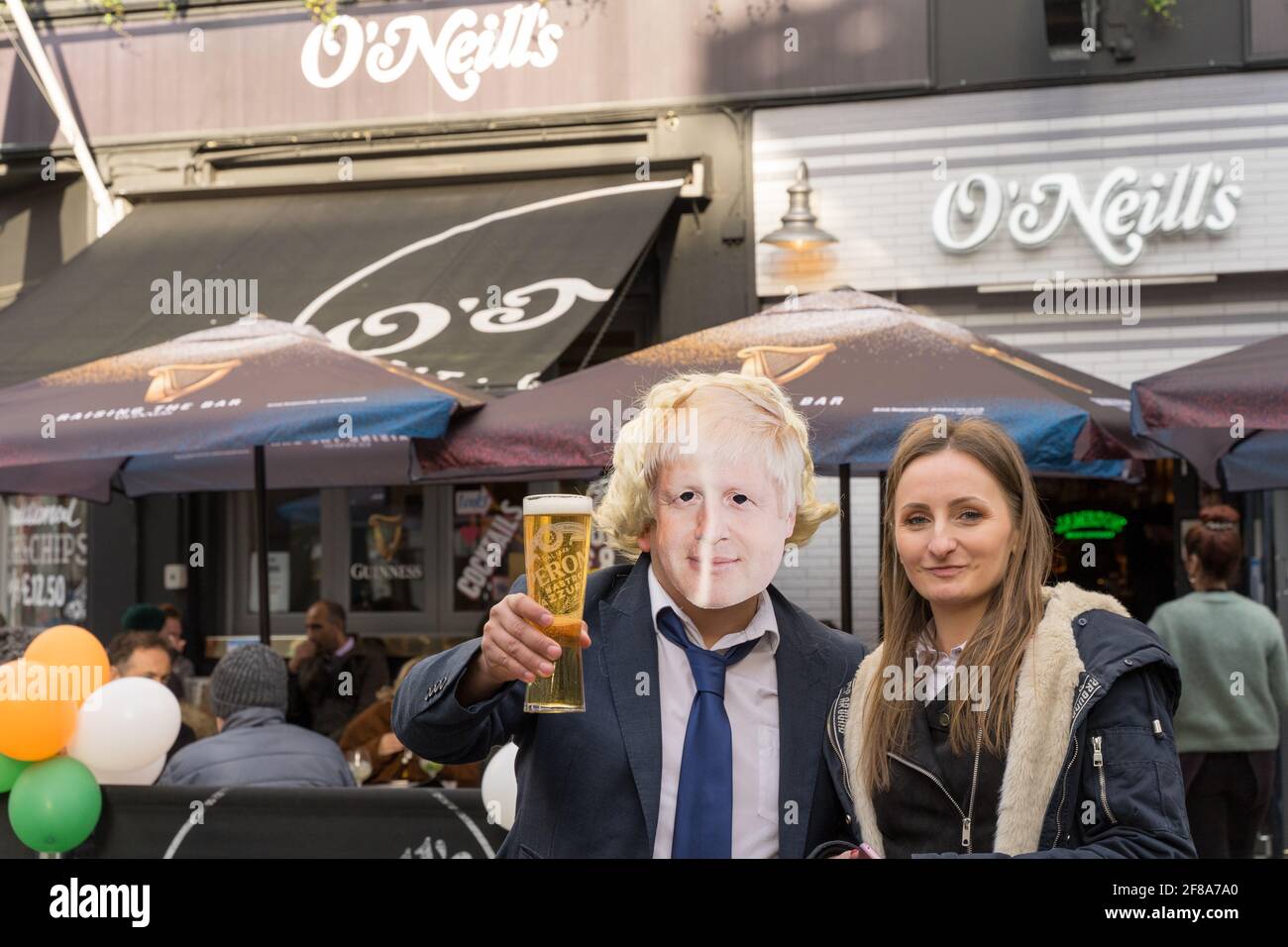 Die junge Frau posiert neben „Boris Johnson“ und hält ein Bier vor dem O'Neil Pub im Londoner West End, in der Nähe des Oxford Circus, Großbritannien Stockfoto