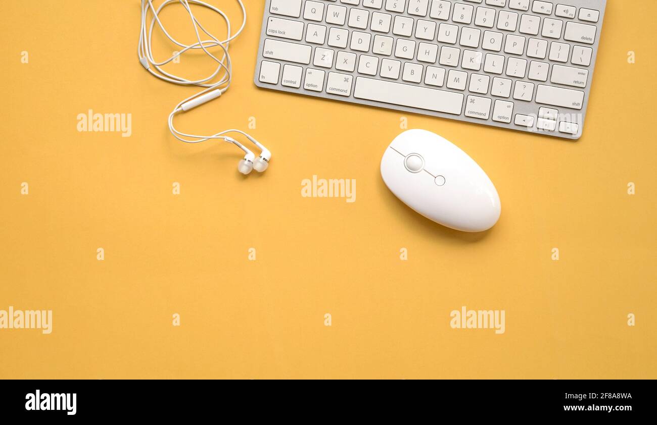 Tastatur, Maus und Kopfhörer auf gelbem Hintergrund. Draufsicht. Speicherplatz kopieren. Stockfoto