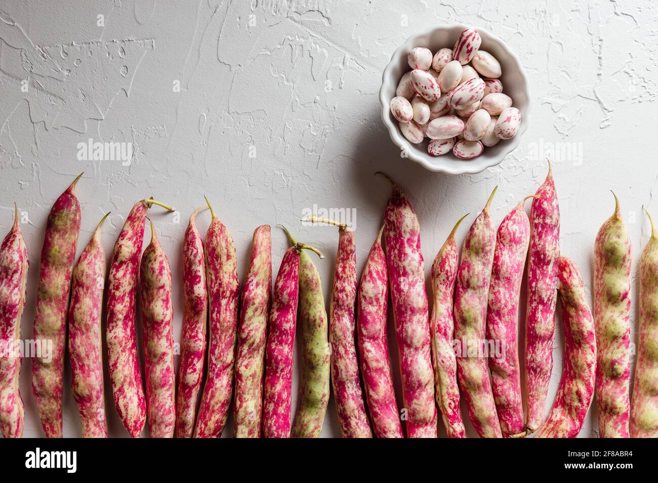 Reihe von bunten Cranberry Borlotti Shell Bohnen mit geschälten Bohnen In White Bowl Stockfoto