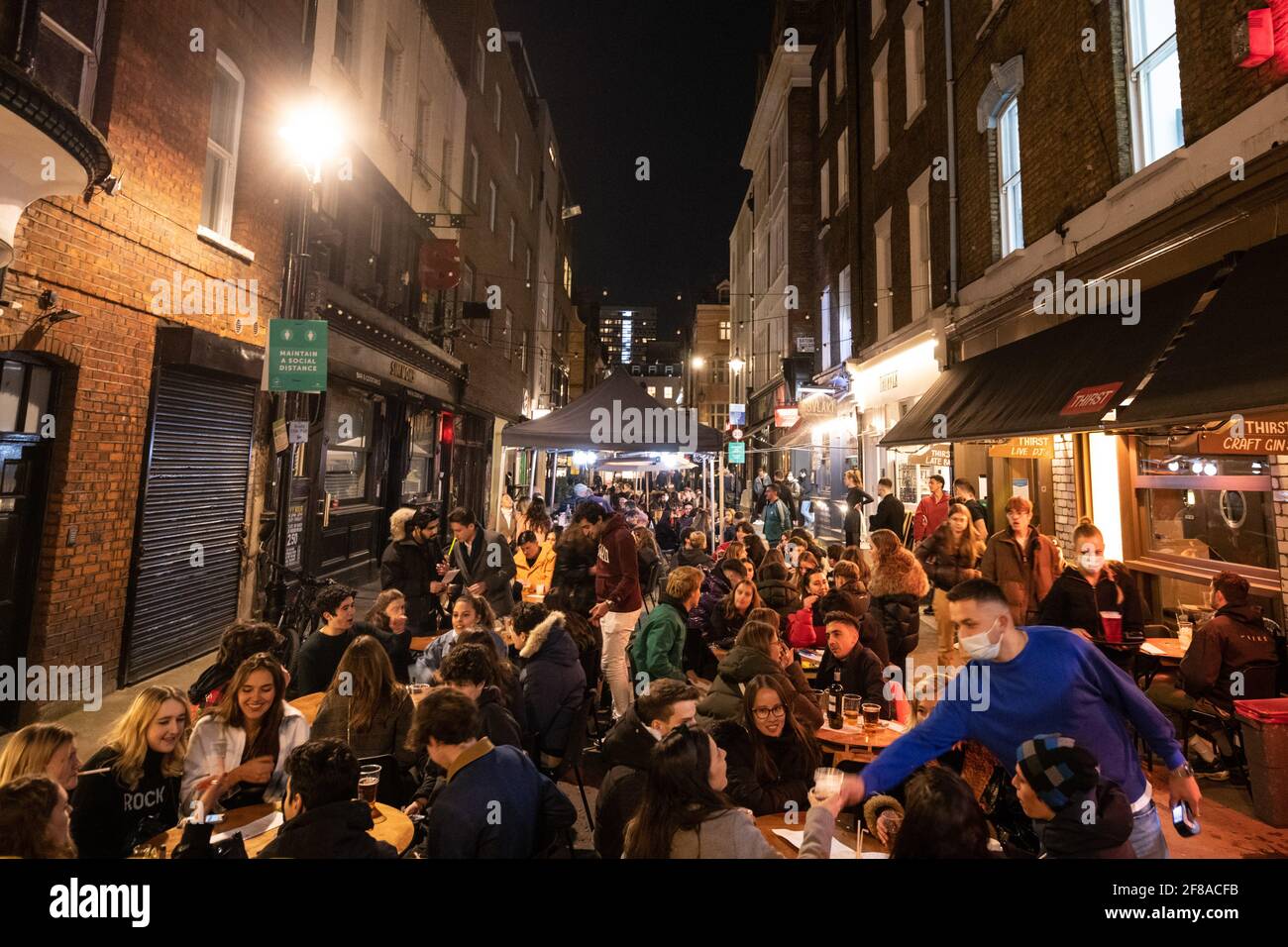 London, Großbritannien. 13. April 2021. Menschen versammeln sich in Soho, London, wo Straßen für den Verkehr gesperrt wurden, als Bars und Restaurants für Essen und Trinken im Freien geöffnet wurden, da die Sperrmaßnahmen in ganz Großbritannien gelockert werden. Bilddatum: Dienstag, 13. April 2021. Bildnachweis sollte lauten: Matt Crossick/Empics/Alamy Live News Stockfoto