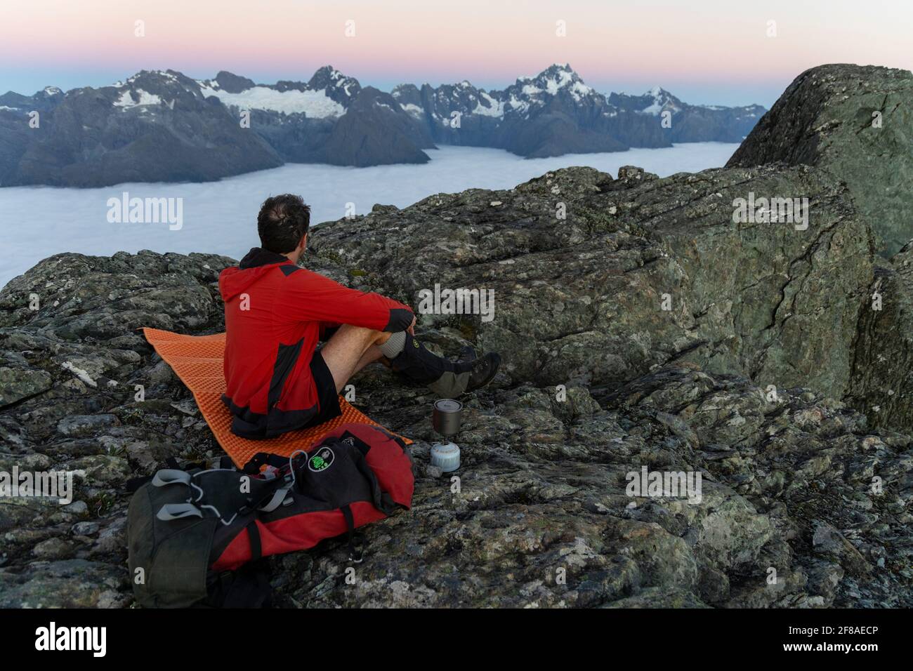 Mann allein beim Sonnenaufgang in den Southern Alps, Neuseeland Stockfoto