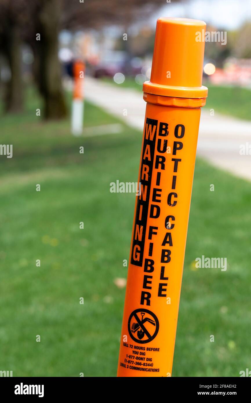 Troy, Michigan - EIN Marker warnt vor dem Graben, da ein vergrabenes Glasfaserkabel vorhanden ist. Stockfoto Troy, Michigan - EIN Marker warnt vor dem Graben, da ein vergrabenes Glasfaserkabel vorhanden ist. Stockfoto