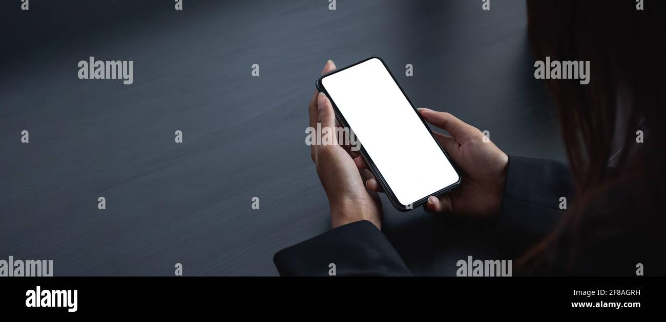 Handy leer weißen Bildschirm mockup. Frau Hand hält SMS mit Handy auf Schreibtisch im Büro.Hintergrund leeren Raum für Werbung. Stockfoto