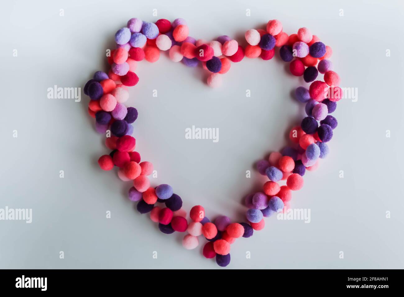 Ein schönes großes Herz aus weichen Pom-Poms vor hellem Hintergrund. Herz Liebe, Liebe Hintergrund, Ort für Text Stockfoto