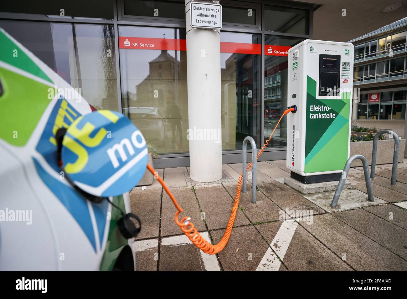 07. April 2021, Sachsen-Anhalt, Halle (Saale): Ein Elektrofahrzeug lädt an einer Ladestation in der Innenstadt. In Halle gibt es allein vom Stadtwerk zwanzig öffentliche Ladestationen. Das Angebot wird auch mit Carsharing mit Elektrofahrzeugen kombiniert. Foto: Jan Woitas/dpa-Zentralbild/ZB Stockfoto