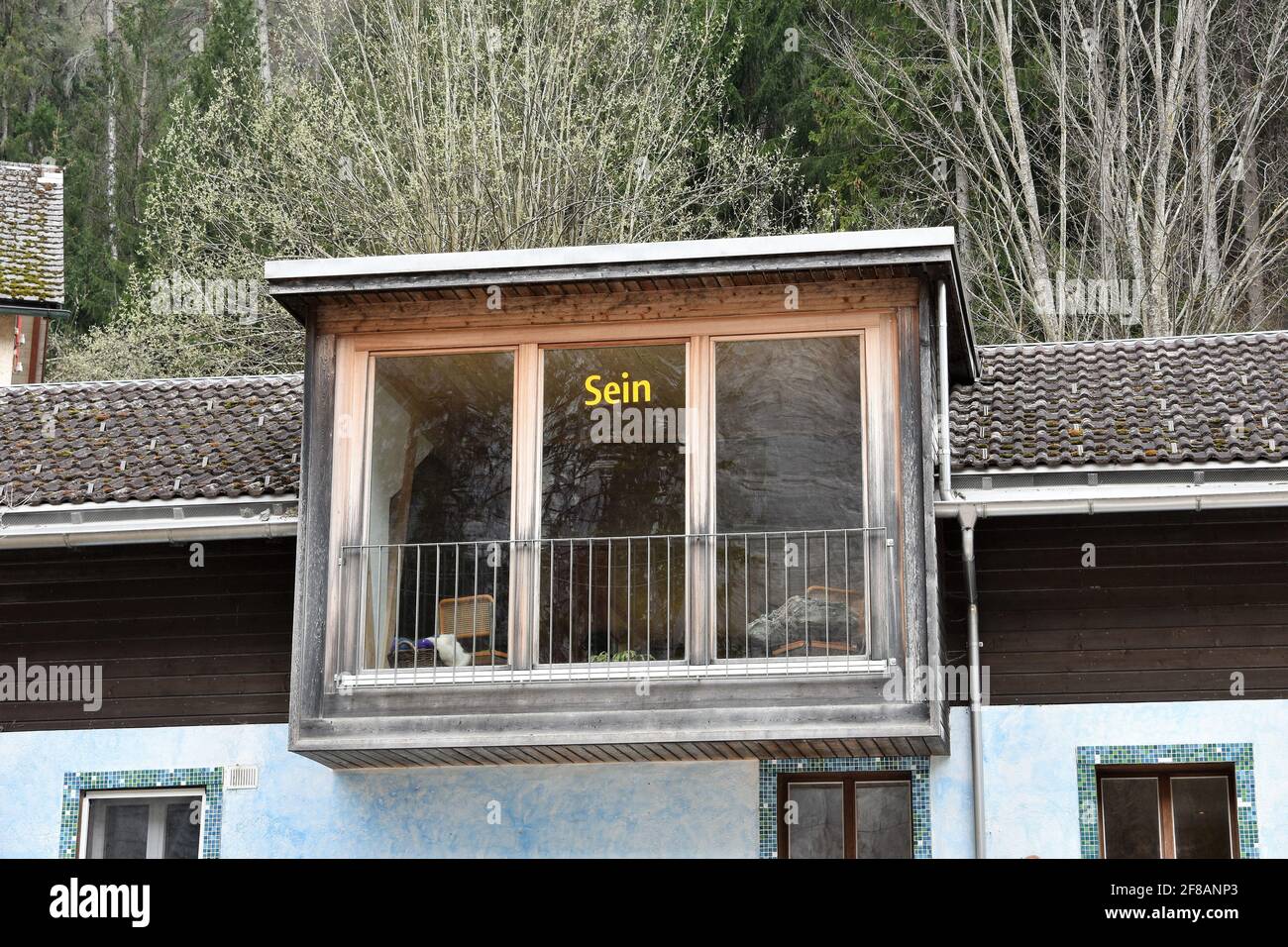 Haus mit französischem Fenster und Inschrift in deutscher Sprache, die sein oder sein bedeutet. Stockfoto