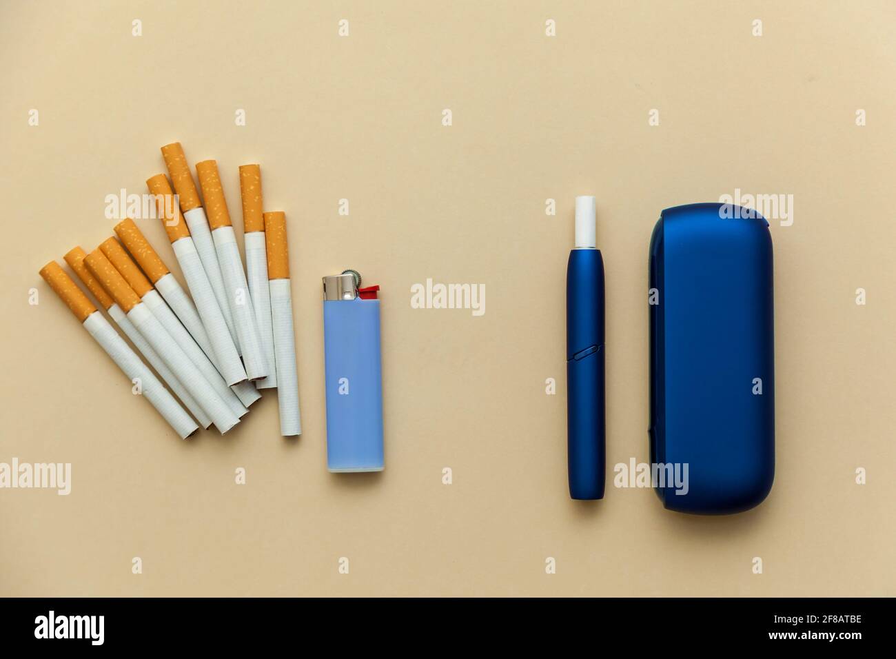Elektronische blaue IQOS-Zigarette, gewöhnliche Zigaretten mit einem  Feuerzeug auf einem beigen Hintergrund. Foto mit Platz für Text, Logo und  Design. Konzept Hea Stockfotografie - Alamy
