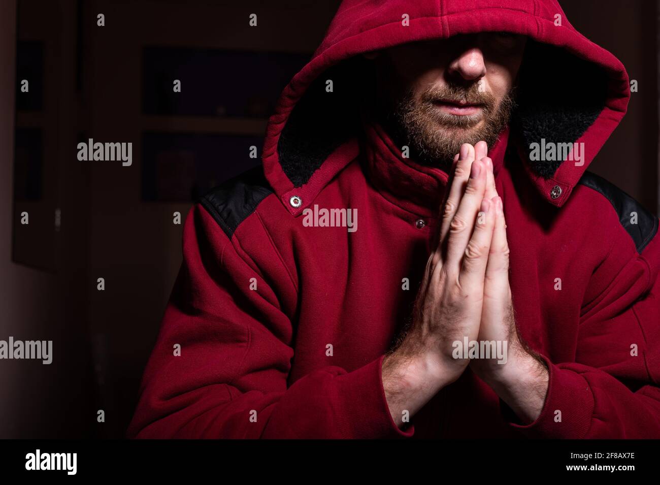Verdächtiger bärtiger Mann in einer Kapuze im Dunkeln Stockfoto