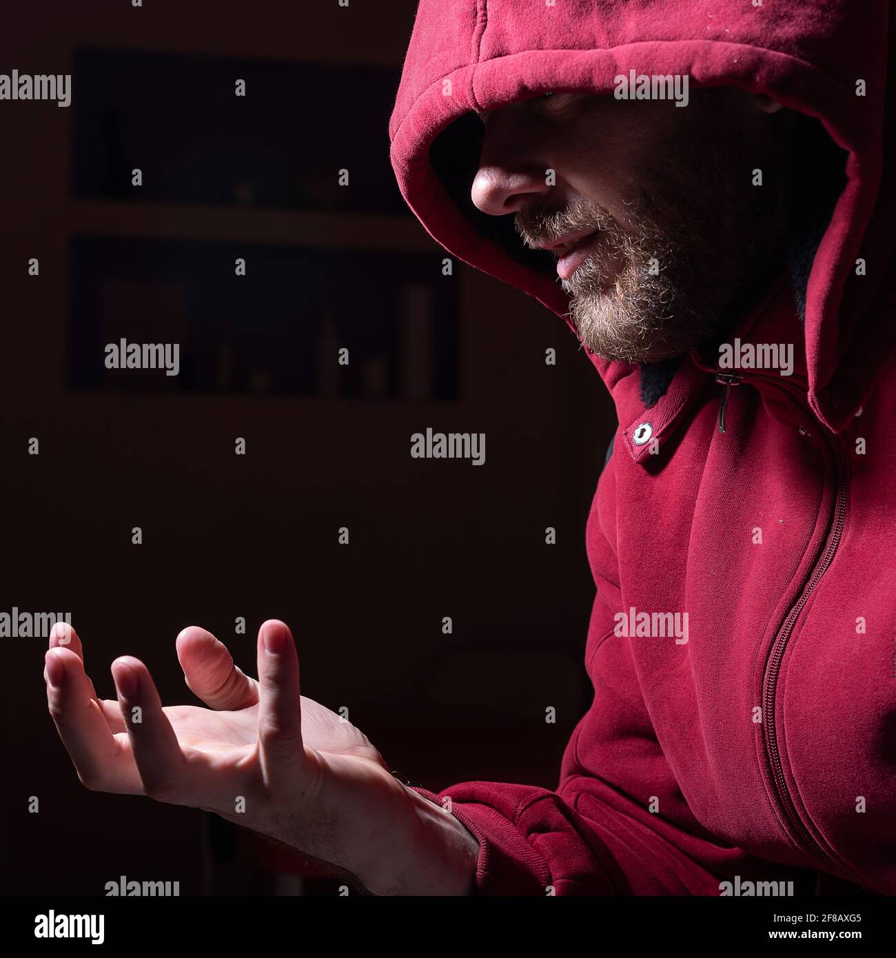 Verdächtiger bärtiger Mann in einer Kapuze im Dunkeln Stockfoto