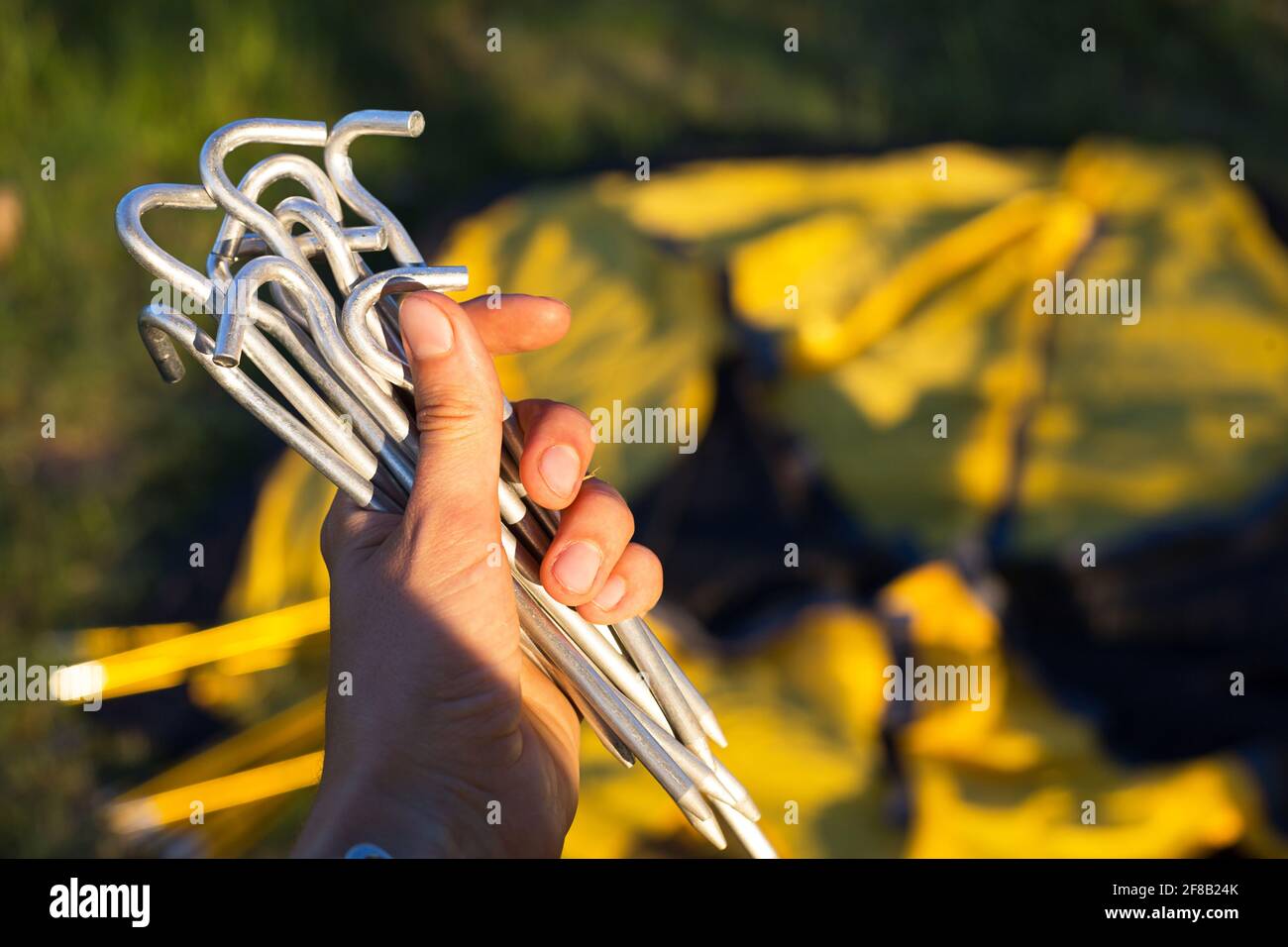 Aluminiumspieße für den Einbau eines gelben Touristenzeltes in der Hand Nahaufnahme. Leichte Ausrüstung für den Tourismus. Outdoor-Aktivitäten, Montage in Stockfoto