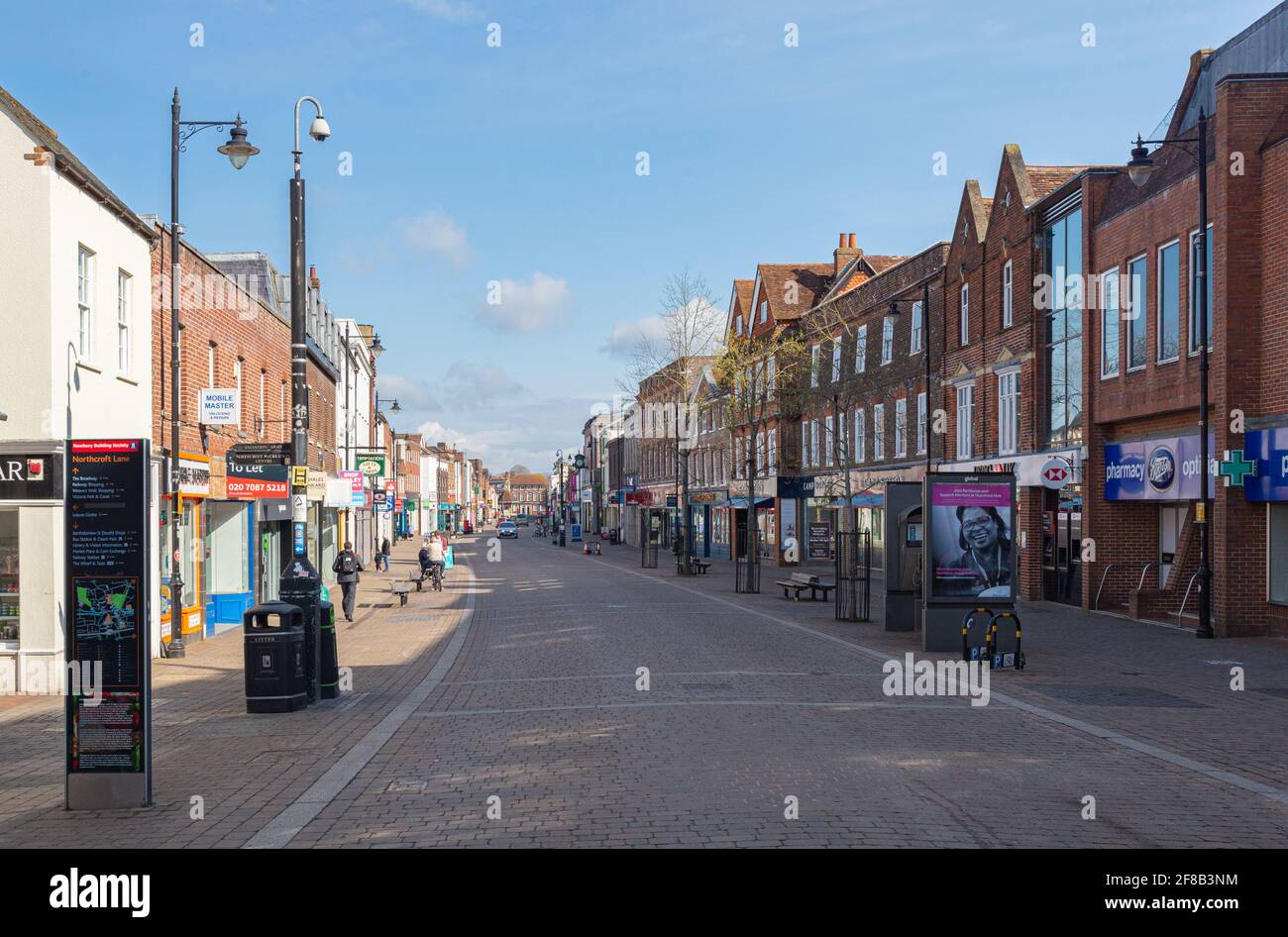 Newbury High Street mit Geschäften und mit rotem Block Pflaster an einem sonnigen Tag mit leichter Wolke. Newbury, Bekshire, England, Großbritannien. Aufgenommen am 11. April 2021. Stockfoto