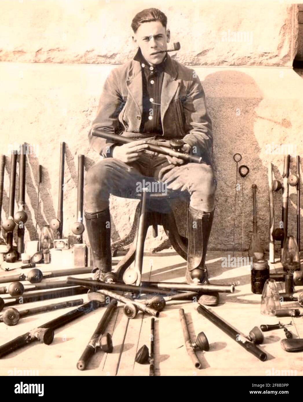Polizist posiert mit Opiumrohren, Lampen und anderen Utensilien, die bei den Opium-Razzien in San Francisco Anfang des 20. Jahrhunderts konfisziert wurden Stockfoto