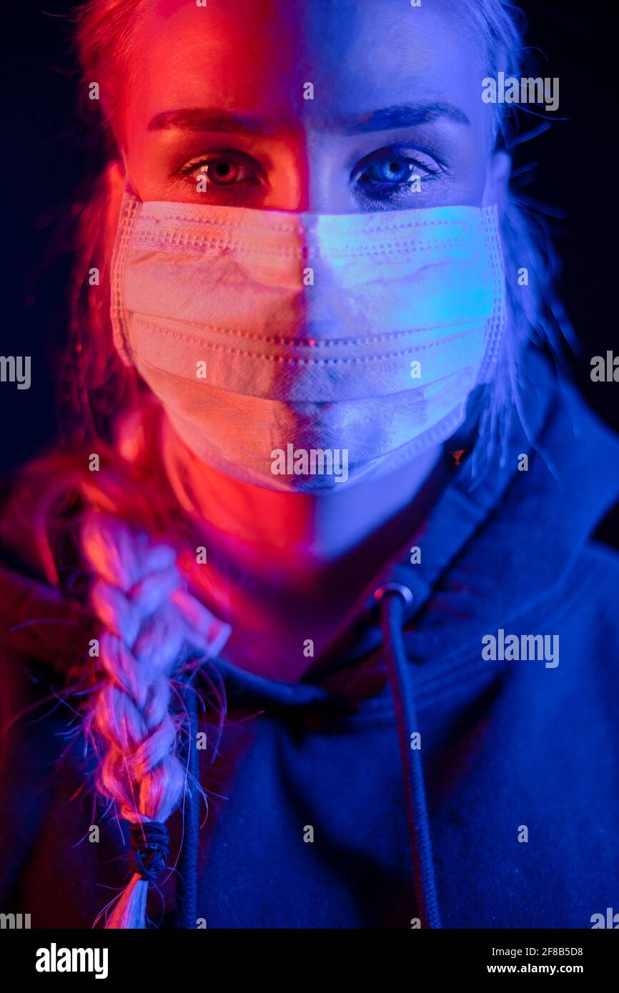 Erschöpft oder krank Frau in schützende Gesichtsmaske mit bunten Lichtern Stockfoto