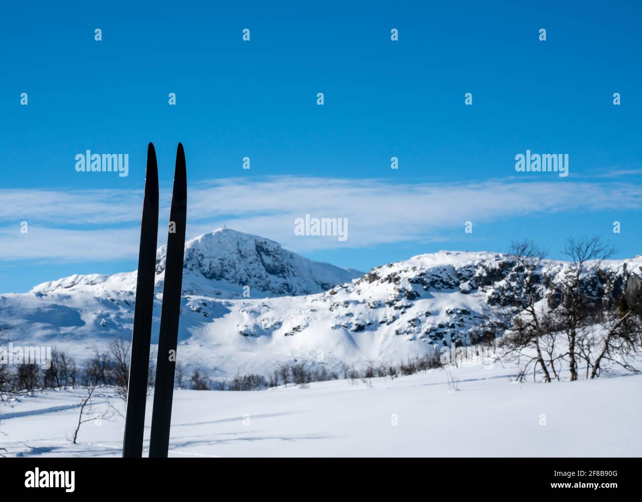 Skier im Schnee mit verschwommenen schneebedeckten Bergen zusammengeschichtet. Stockfoto