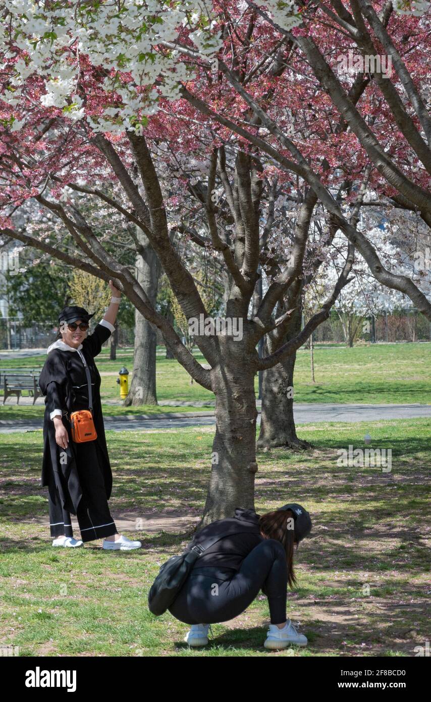 2 Asiatisch-amerikanische Frauen machen Fotos und Selfies im Frühling im Flushing Meadows Corona Park in Queens New York City. Stockfoto