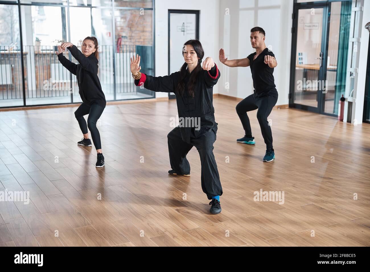 Der Meister des ruhigen Tai Chi übt mit der Gruppe eine Peitsche Stockfoto