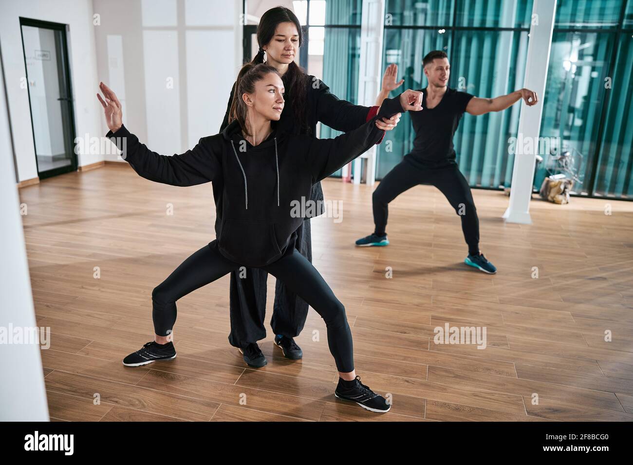 Kursleiter passt die Armposition des Tai Chi-Schülers an Stockfoto