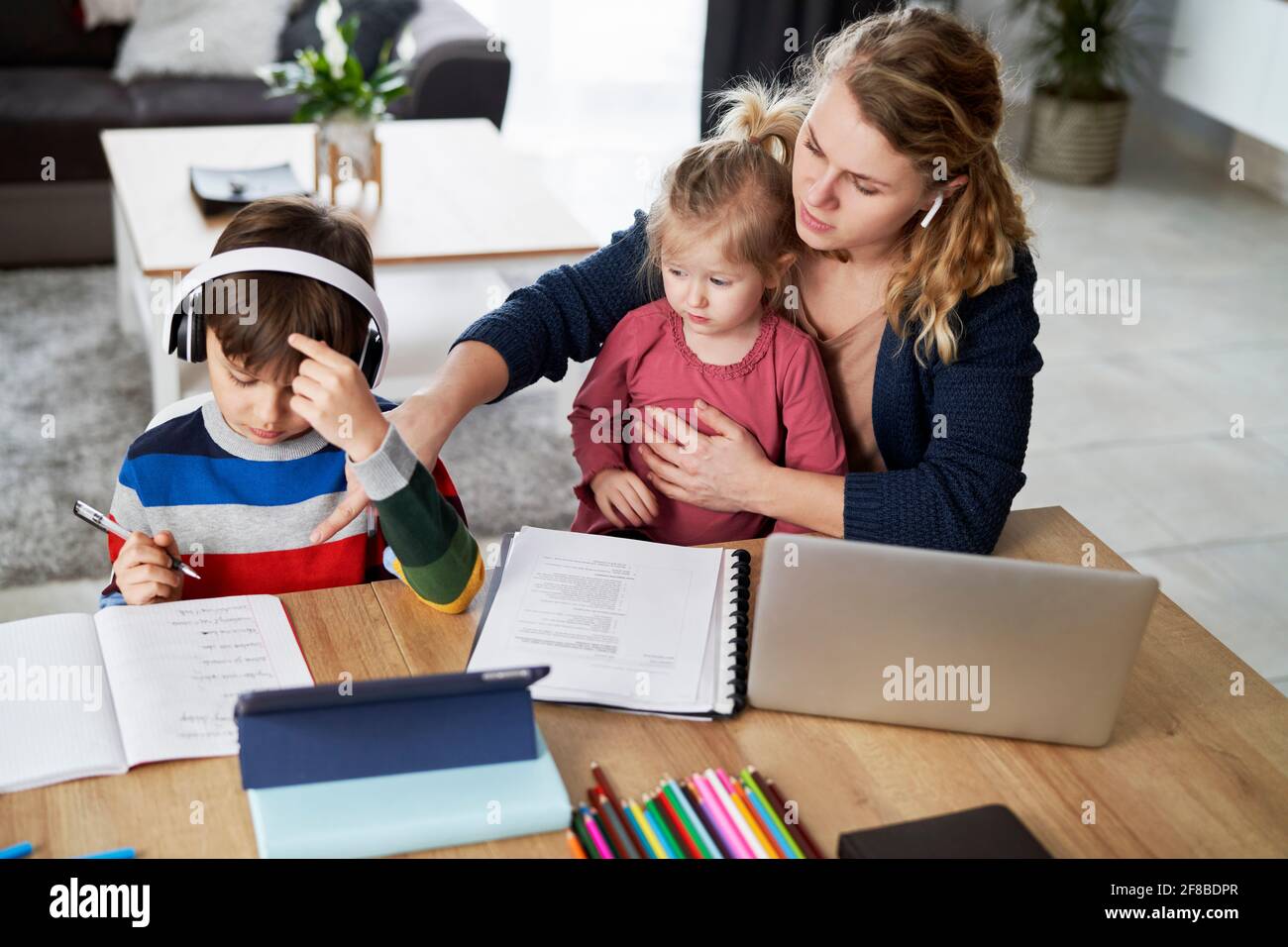 Mutter während des Heimbüros und der Unterstützung von Kindern in der Bildung Stockfoto