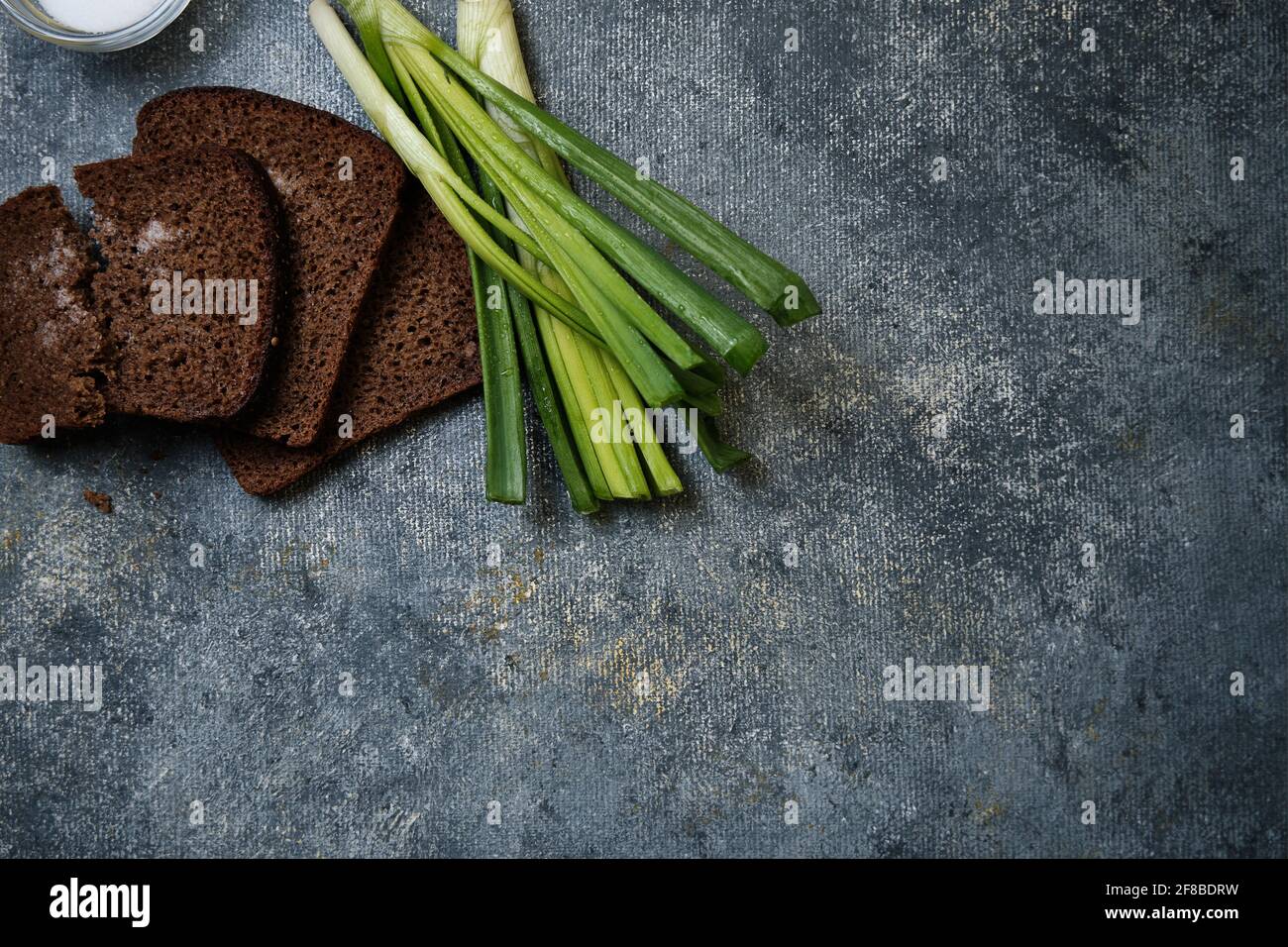 Brot mit Salz, grüne Zwiebeln mit Wassertropfen Stockfoto
