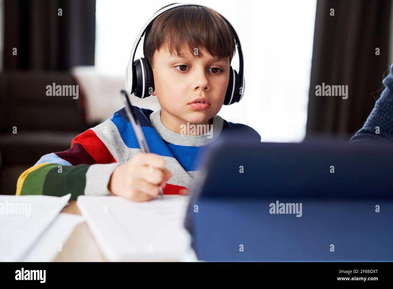 Junge in Kopfhörer während der Heimschooling Stockfoto