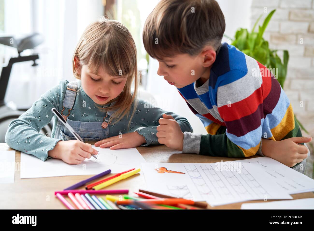 Großer Bruder hilft seiner Schwester bei ihren Hausaufgaben Stockfoto