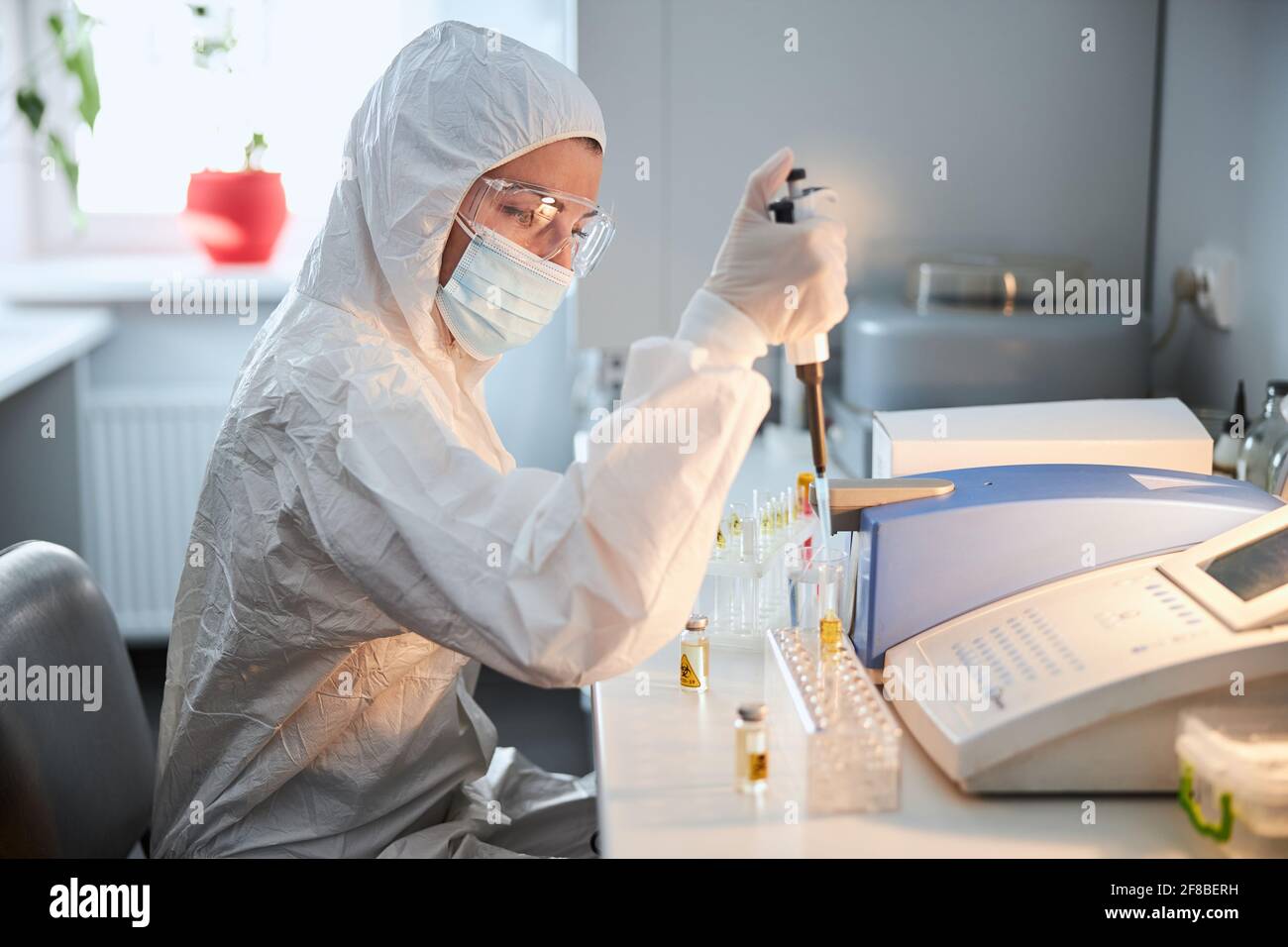 Wissenschaftler in einem Hazmat Anzug Durchführung der Forschung auf einem hoch Pathogenes Coronavirus Stockfoto