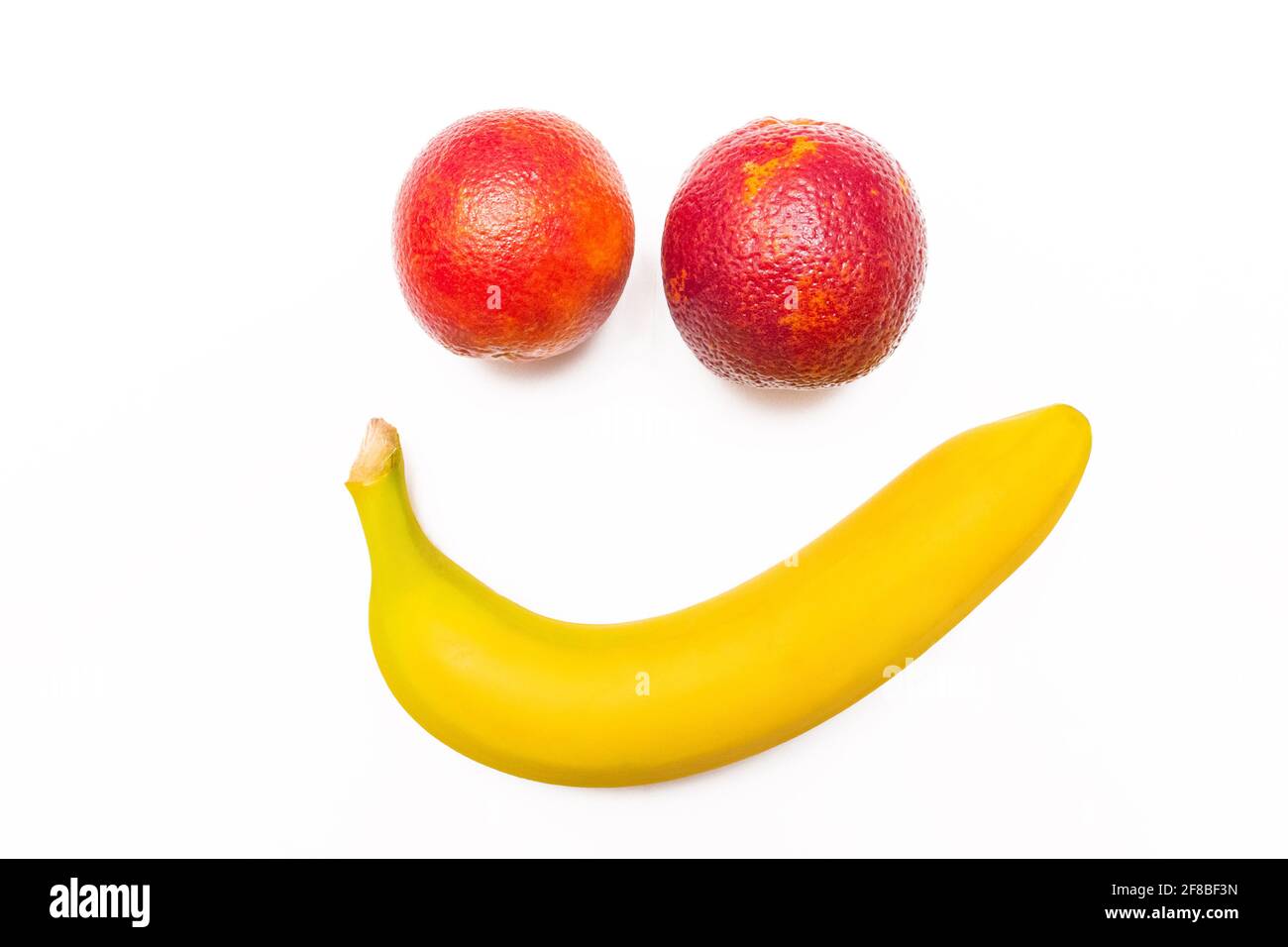 Lächelnde Banane und lustige rote Orange isoliert auf weißem Hintergrund. Stockfoto