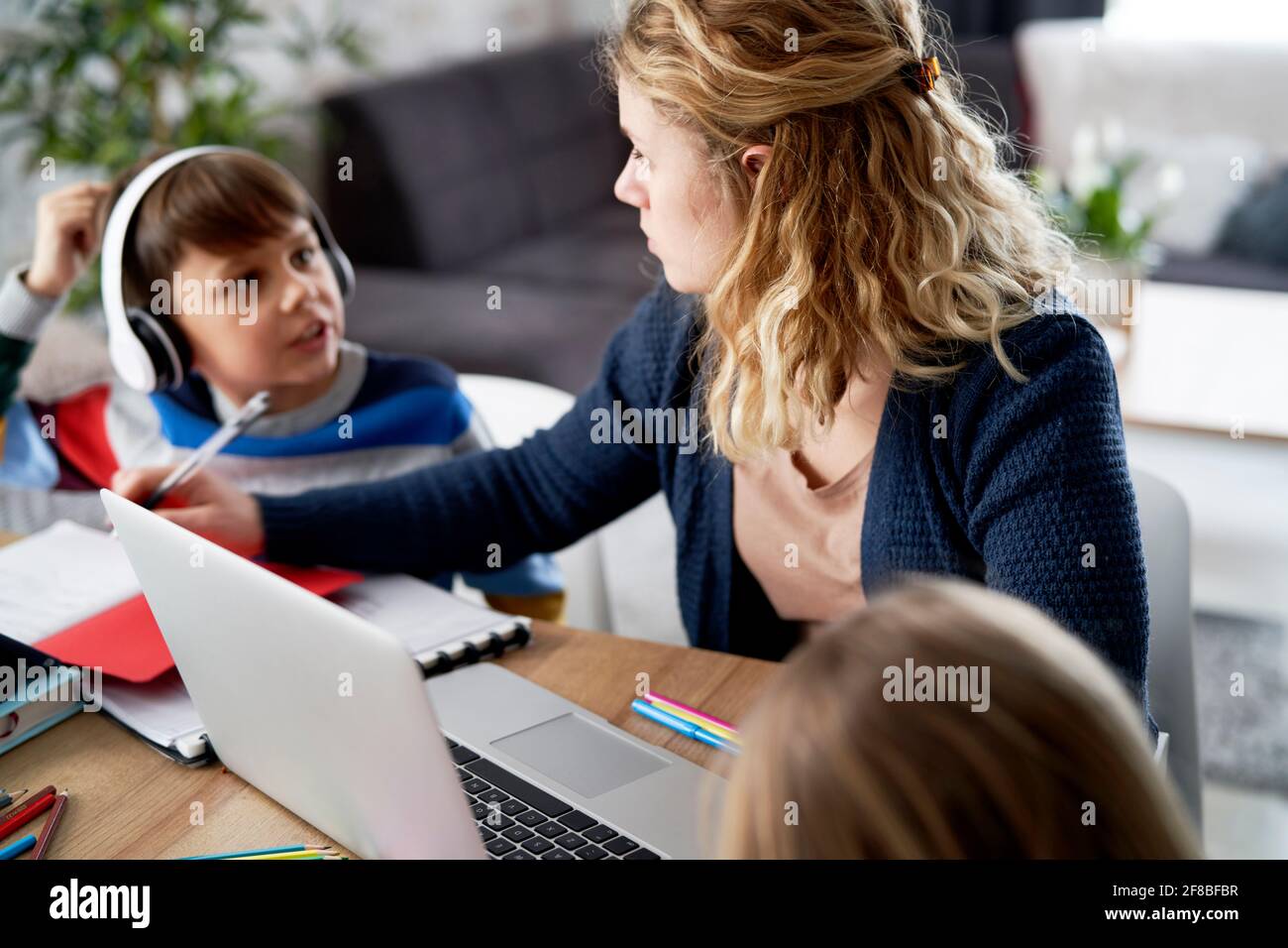 Sohn unterbricht seine Mutter während des Heimbüros Stockfoto