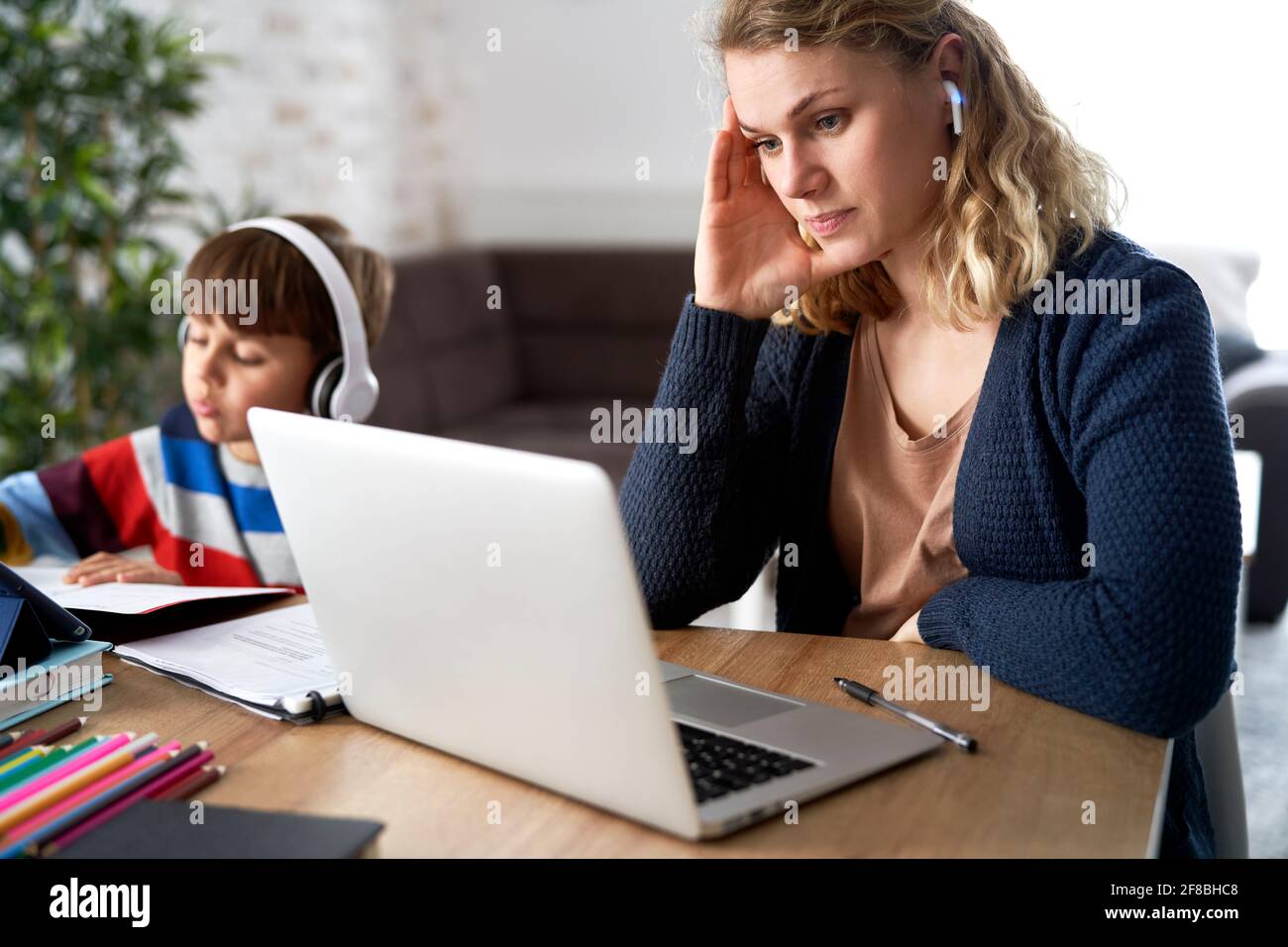 Frustrierte Mutter während des Heimbüros mit ihrem Sohn zu Hause Stockfoto