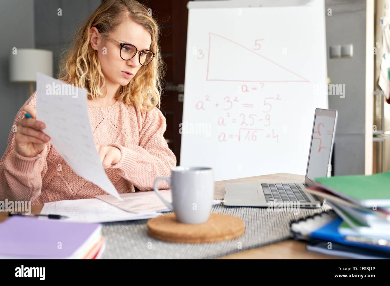 Die junge Lehrerin zeigt den Schülern, wie sie während der Heimsschooling Materialien lernen Stockfoto