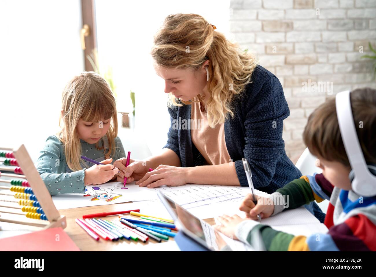 Mama hilft ihren Kindern beim Heimschooling während des Lockdown Stockfoto