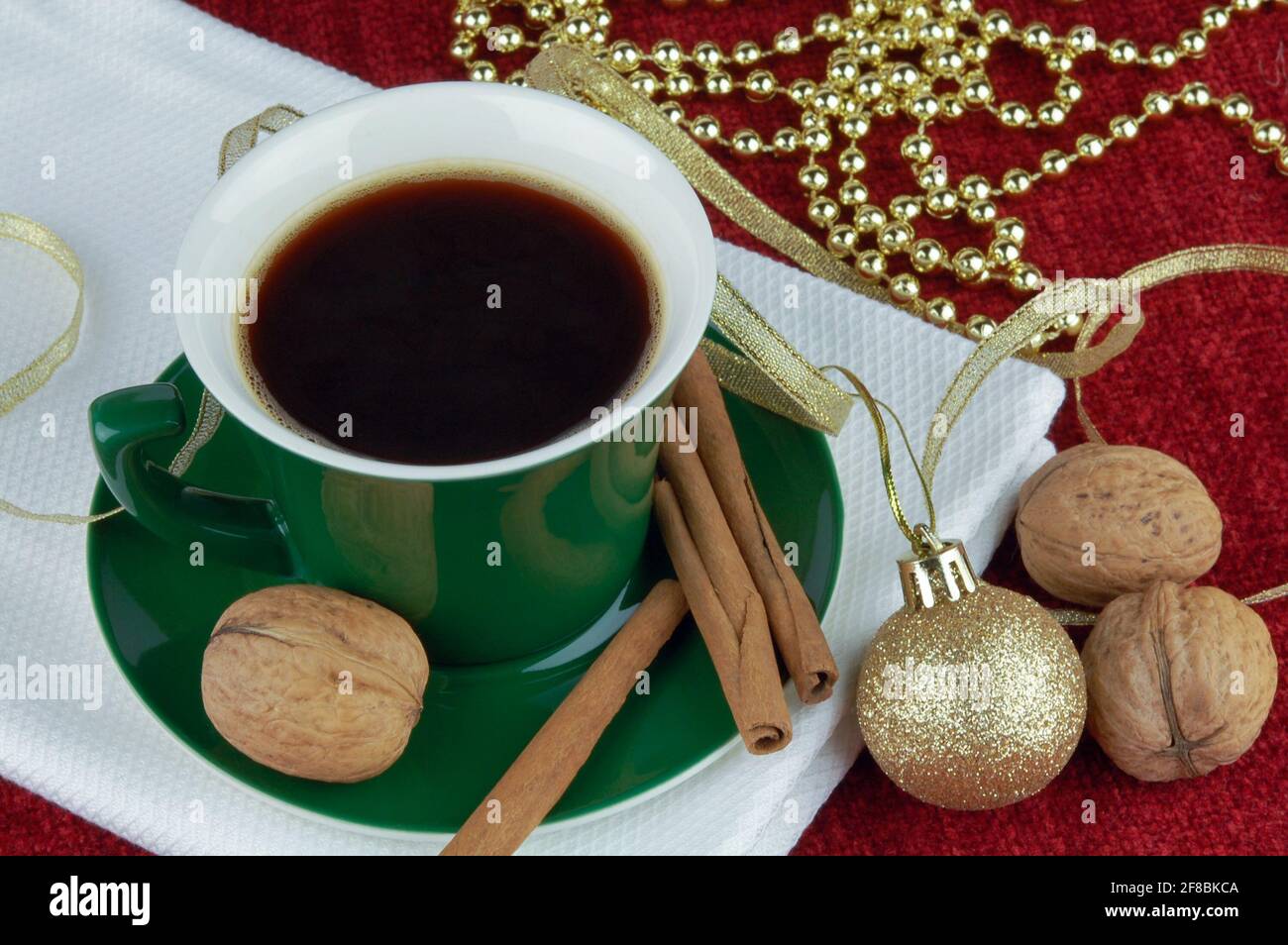 Kaffeetasse mit Zimt, Walnüssen und weihnachtlicher Dekoration. Neujahrs- oder Weihnachtskarte. Stockfoto