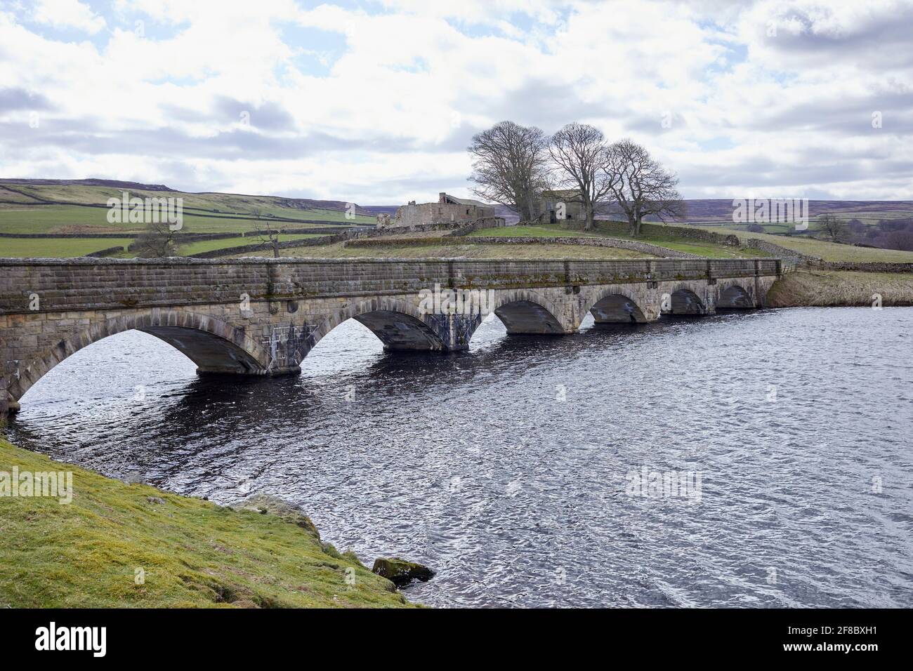 6 gewölbte Steinbrücke über den Roundhill Stausee, die sich dem Round Hill nähert Bauernhof Stockfoto