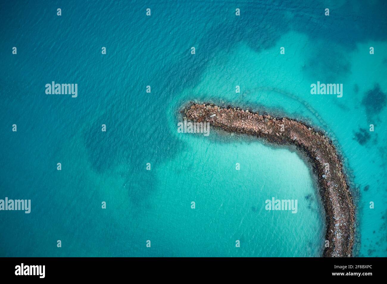 Luftaufnahme der natürlichen Steinbarriere in kristallblauem Wasser auf Praslin, Seychellen. Stockfoto