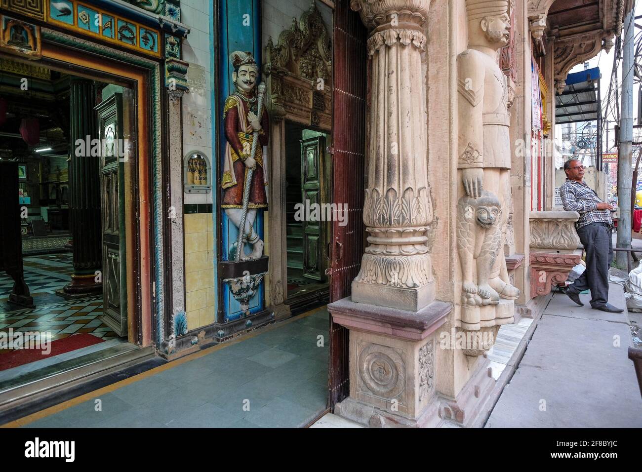 Indore, Indien - 2021. März: Ein Mann, der sich am 12. März 2021 in Indore, Madhya Pradesh, Indien, an der Fassade eines Jain-Tempels in Sarafa Bazaar lehnt. Stockfoto