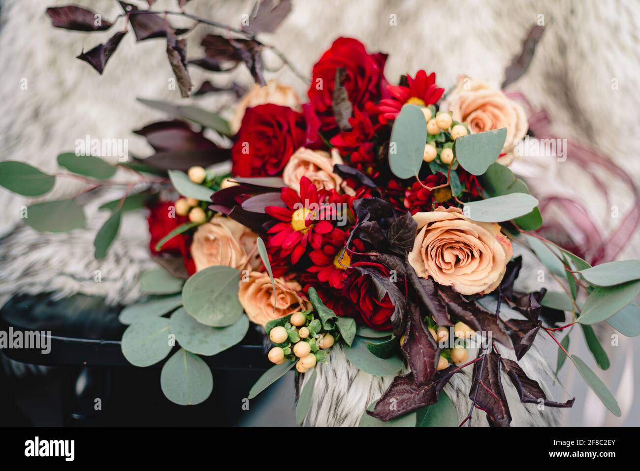 Hochzeit Blumenstrauß auf dem Stuhl gegen weißes Fell ausgestellt Mantel Stockfoto