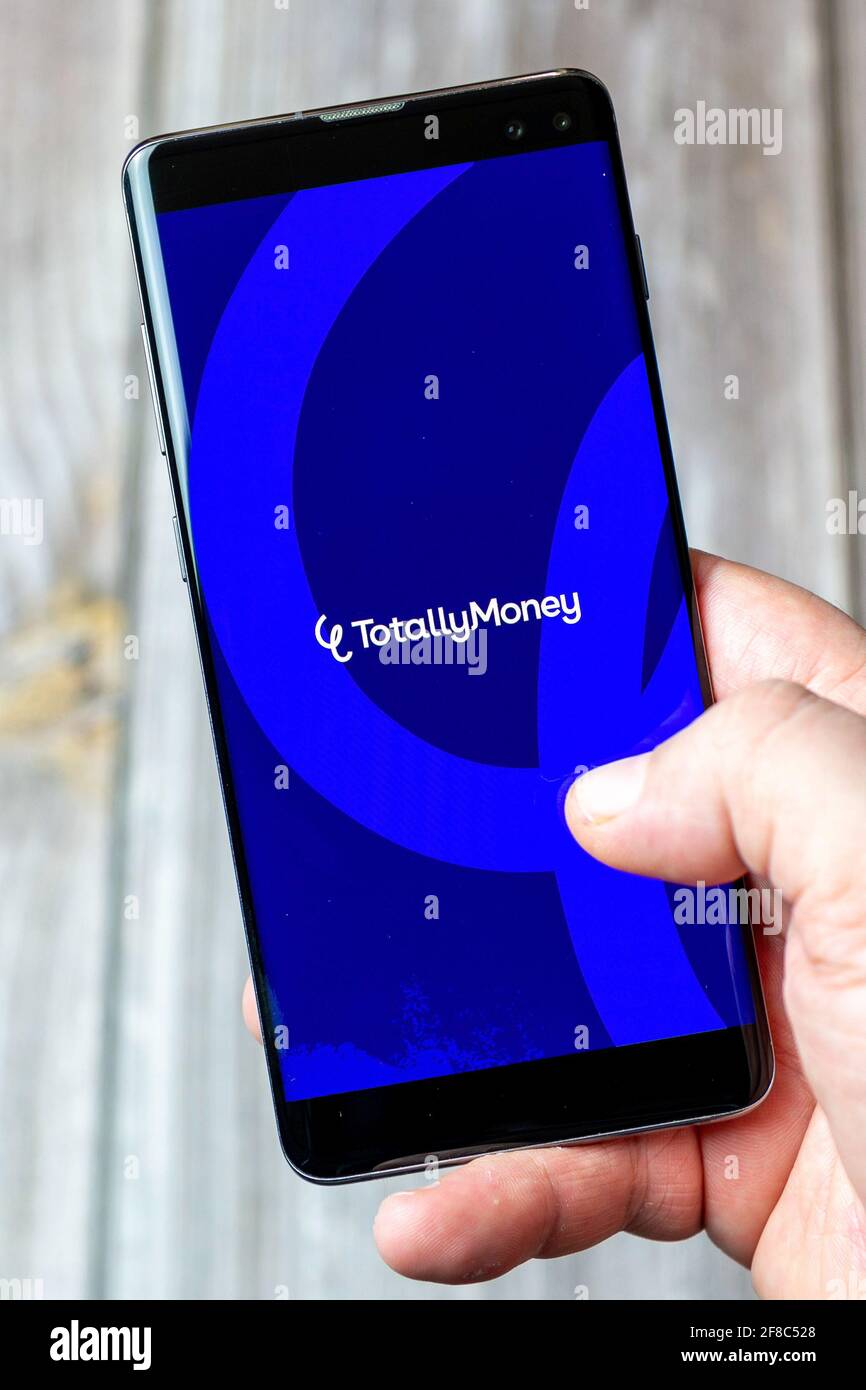 Ein Mobiltelefon oder Mobiltelefon, das in einem gehalten wird Hand mit der Totally Money App auf dem Bildschirm geöffnet Stockfoto
