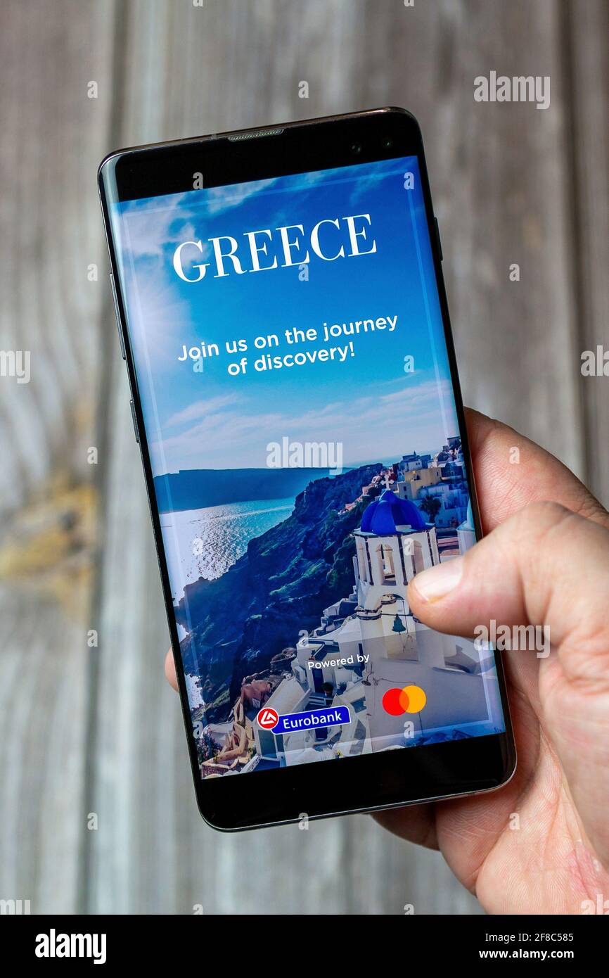 Ein Mobiltelefon oder Mobiltelefon, das in einem gehalten wird Hand mit der Visit Greece App auf dem Bildschirm geöffnet Stockfoto