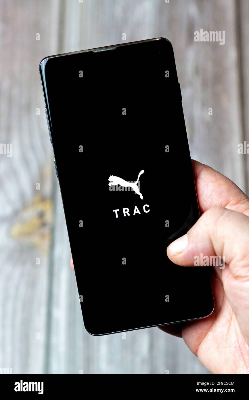 Ein Mobiltelefon oder Mobiltelefon, das in einem gehalten wird Hand mit der  Puma Trac App auf dem Bildschirm geöffnet Stockfotografie - Alamy