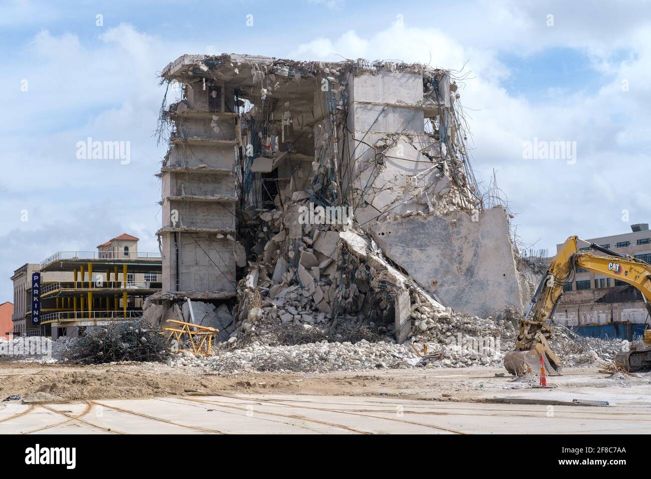 NEW ORLEANS, LA, USA - 28. FEBRUAR 2021: Überreste des eingestürzten Hard Rock Hotels, Parkgarage und Bagger auf der Rampart Street Stockfoto