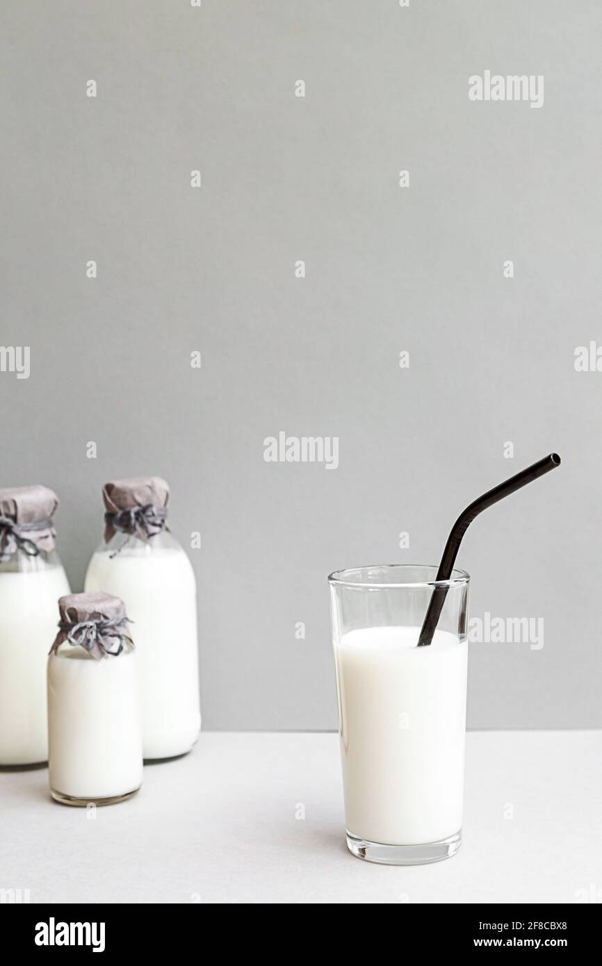 Minimale Standzeit von Milchflaschen auf hellem Hintergrund mit Platz für Kopien. Milchproduktion, Bio-Produkt. Das Konzept der gesunden Ernährung und Sustain Stockfoto