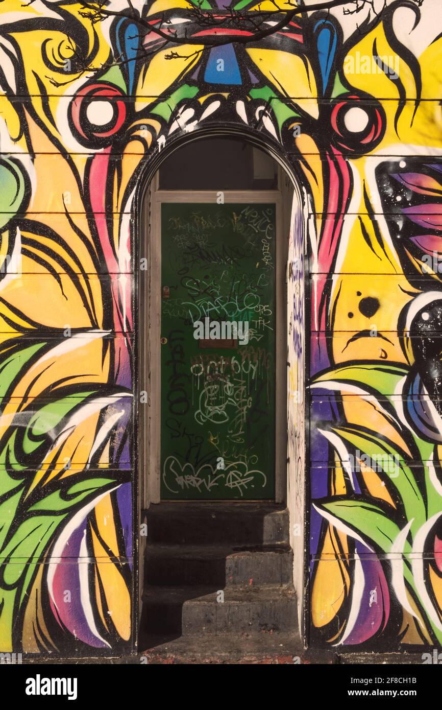Eintritt in ein Hockehaus in London, bedeckt mit Graffiti-Tags und mit Street Art von einem klaffenden Mund, Camden Town, London, Vereinigtes Königreich Stockfoto