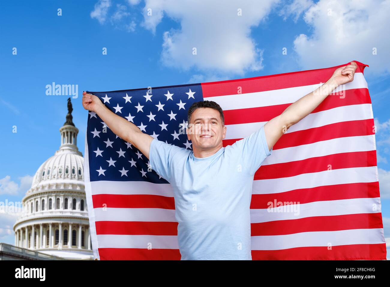 Der Mann hält die amerikanische Flagge in ausgestreckten Armen Stockfoto