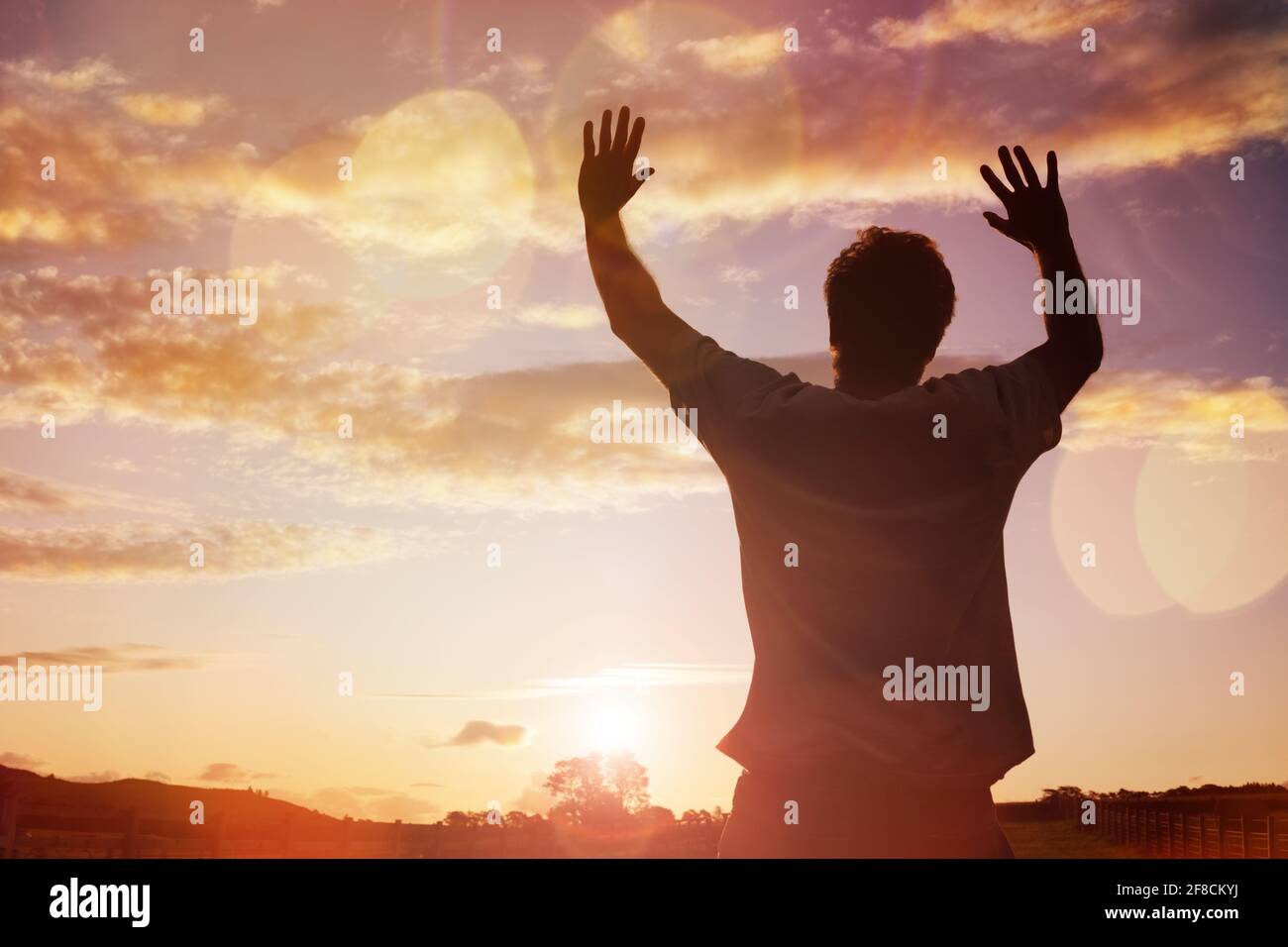 Silhouette eines Mannes mit Händen in den Sonnenuntergang Konzept für Religion, Gottesdienst, Gebet und Lobpreis angehoben Stockfoto