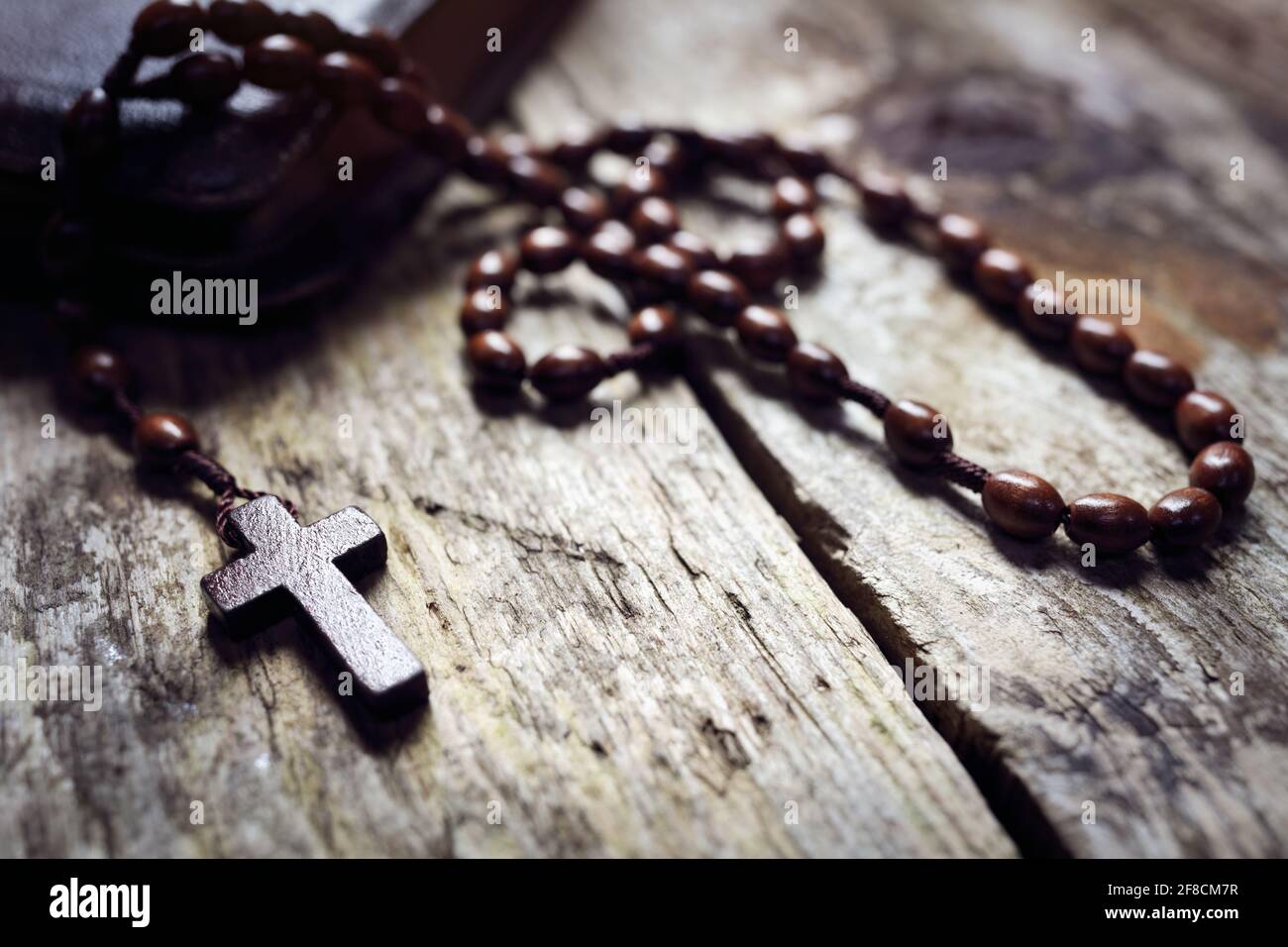 Rosenkranz Perlen und Kruzifix Kreuz auf heilige bibel Hintergrund Stockfoto