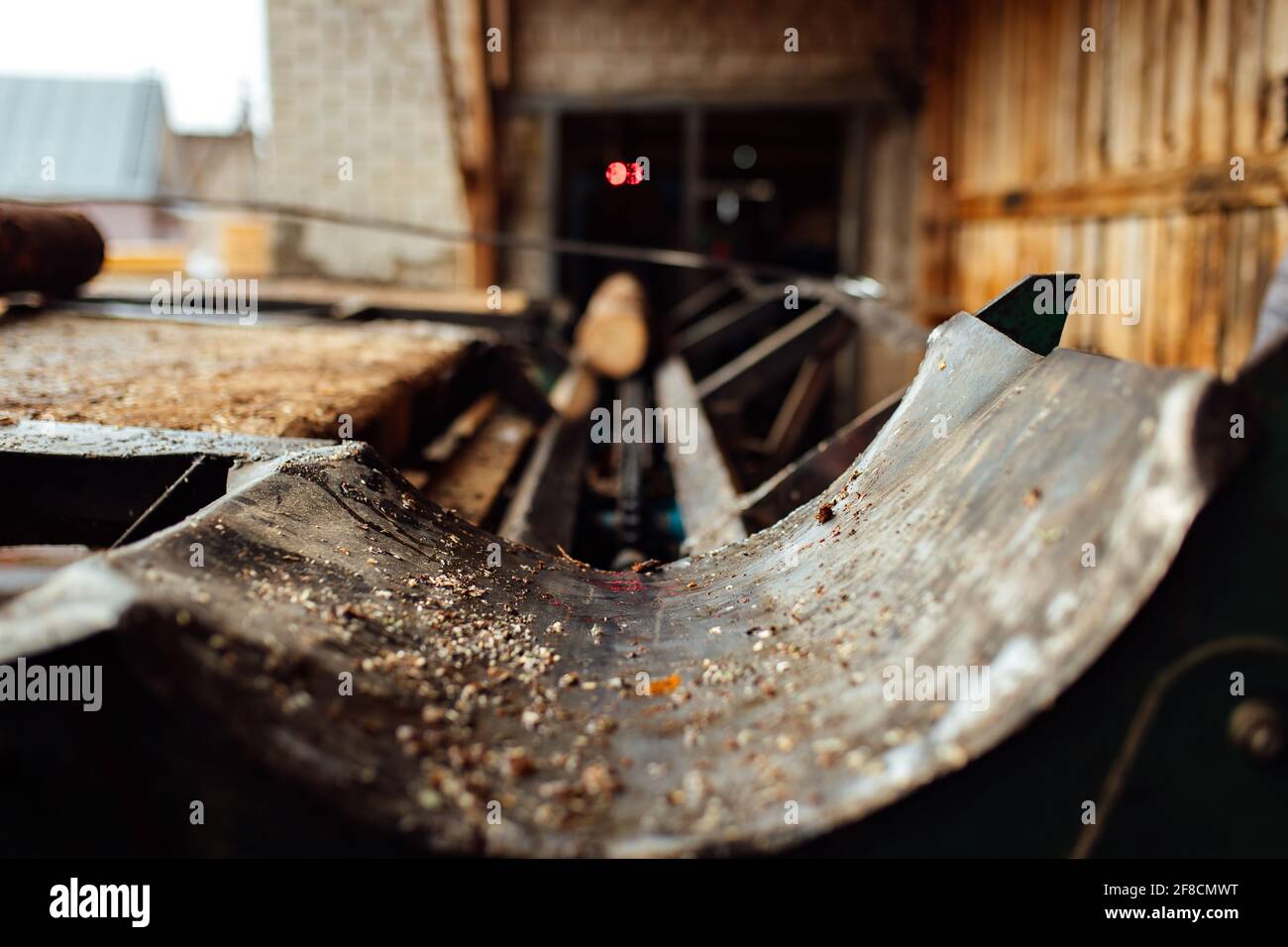 Ein Log auf einem Förderband. Transport von Holzrohstoffen in der Anlage. Holzbearbeitung auf einem Sägewerk. Automatisierter Förderer Stockfoto